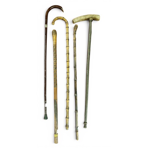 12 - A group of Walking Canes to include a Whangee bamboo cane, a hardwood and horn cane stamped Gaua (po... 