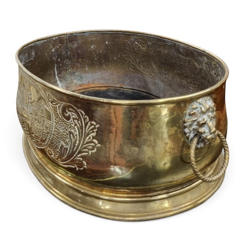 18 - A good 19th Century Brass oval table top wine Cooler with embossed detail and lions head lifting han... 