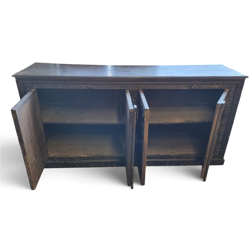 13 - A 19th Century raddled Continental low four door Cabinet with highly carved outline.
W 198 x D 47 x ... 
