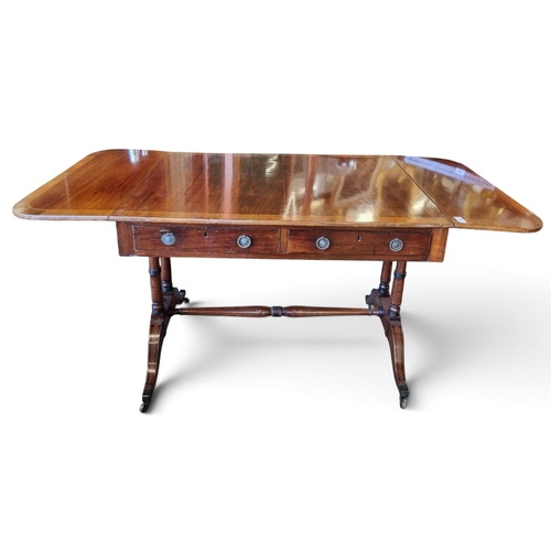44 - A Regency Mahogany and Inlaid Sofa Table with twin frieze drawers and splayed supports and Brass cas... 