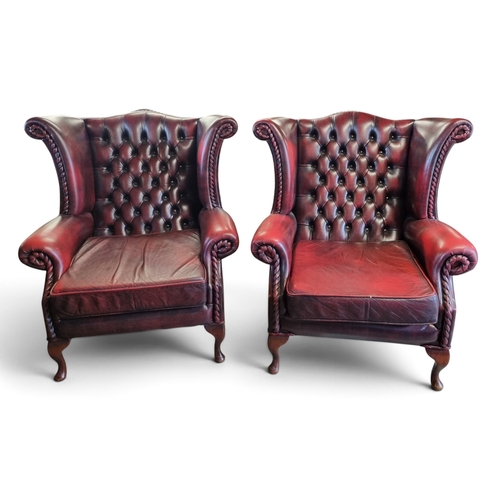 57 - A good pair of Wingback Chairs with deep button backs and ox blood coloured design. W 88 x SH 44 x B... 