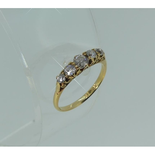 119 - A graduated five stone diamond Ring, in an 18ct yellow gold scroll mount, Size M.