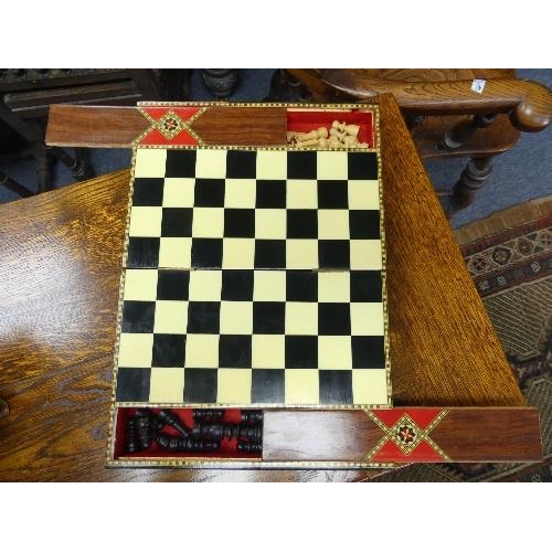 160 - A decorative inlaid folding Chess Board, with compartments containing ebony and boxwood chess pieces... 