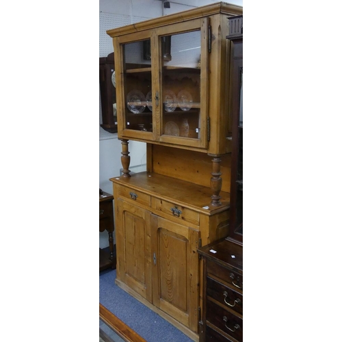 165 - A French stripped pine Dresser, the top section with glazed doors and turned supports, on a base wit... 