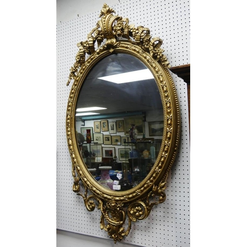 167A - A 19th century giltwood oval Wall Mirror, the oval plate set within a moulded frame with foliate rib... 