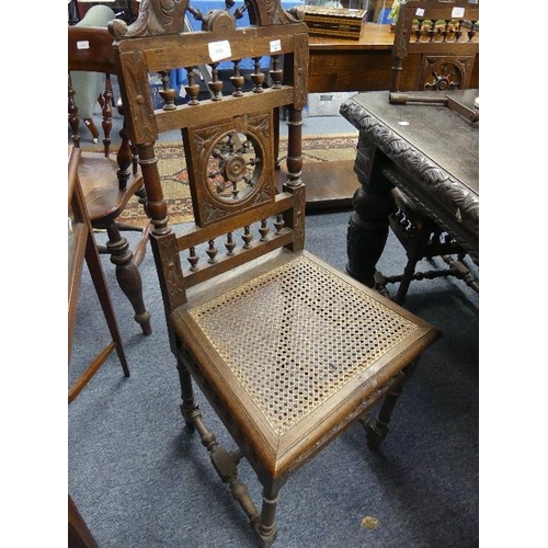 169 - A set of five late Victorian carved oak wheel-back Dining Chairs, with caned seats, one chair damage... 