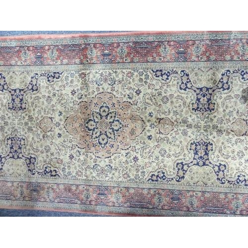 210 - Tribal Rugs;  a Kashmiri style silk rug, with cream ground and pink border, 117in x 32in (297cm x 80... 