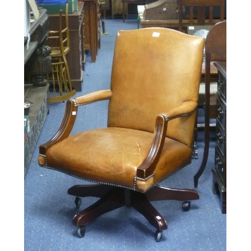 356A - A brown leather revolving Desk Chair, rip to seat, 24in (61cm) wide.