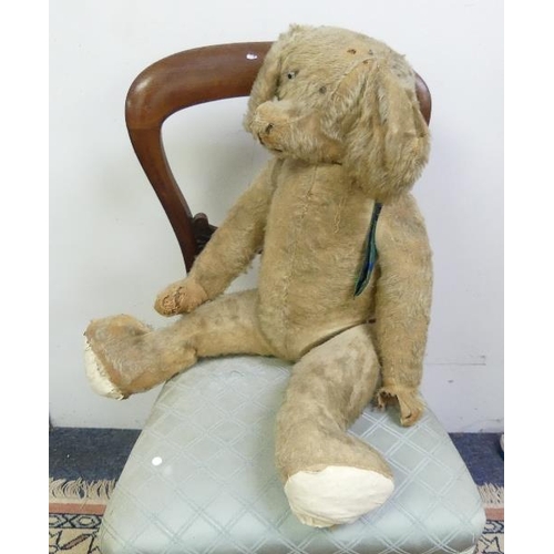 667 - An early 20thC straw-filled plush Teddy Bear, with pointed nose, hump and growler, play worn and in ... 