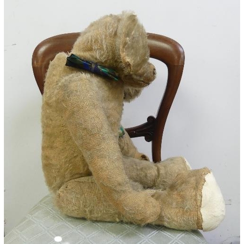 667 - An early 20thC straw-filled plush Teddy Bear, with pointed nose, hump and growler, play worn and in ... 