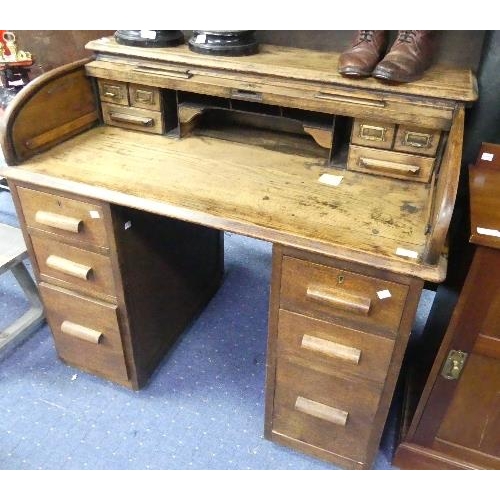 121 - An early 20thC oak Roll-top Desk, named 'The Ebus Desk', comprising fitted compartments on six drawe... 