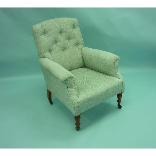 453 - A Victorian upholstered button back Armchair, raised on turned mahogany legs and casters.