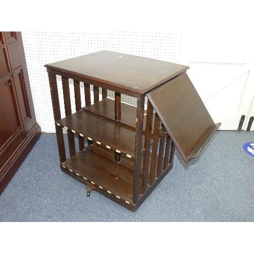 478 - An early 20th century oak revolving Bookcase, fitted with a folding book-stand, the rectangular top ... 