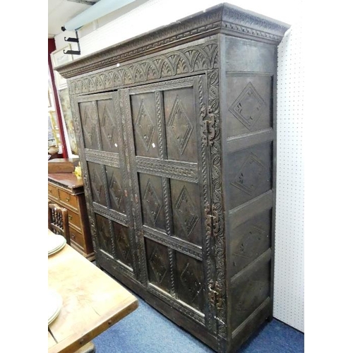 480 - An antique carved oak two-drawer Cupboard, the cornice above panelled sides and doors, the whole car... 