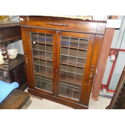 69 - A small Arts and Crafts-style oak bookcase, with two glazed doors, some glass missing, height 45in x... 