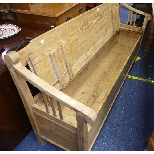 86 - An early 20thC continental stripped pine box Settle/Bench, with open slat back and arms and box seat... 