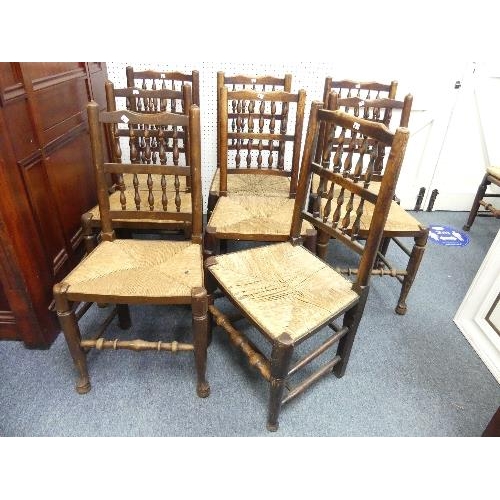 476 - A set of seven ash and elm spindle-back country farmhouse dining chairs, with rush seats, together w... 