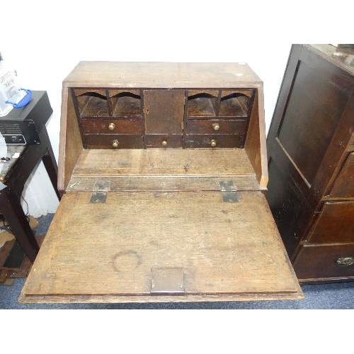 491 - A small Georgian oak Bureau, the fall front with fitted interior, above three long drawers, bracket ... 