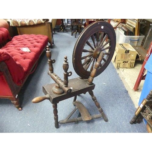 102 - A vintage oak Spinning Wheel, 34in (86.5cm) long, 22in (56cm) wide, 39in (99cm) high.