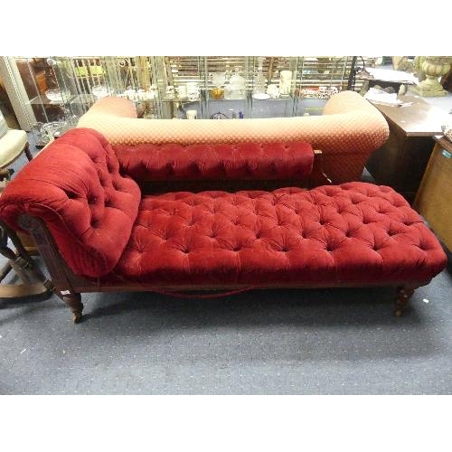 104 - A Late Victorian mahogany-framed Chaise Longue, button-back with red upholstery, raised on turned le... 