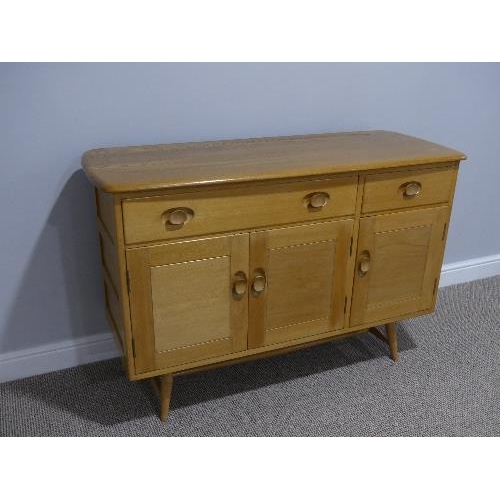 3 - A mid 20thC Ercol light elm and beech Sideboard, Model 351, with a long drawer above a double cupboa... 