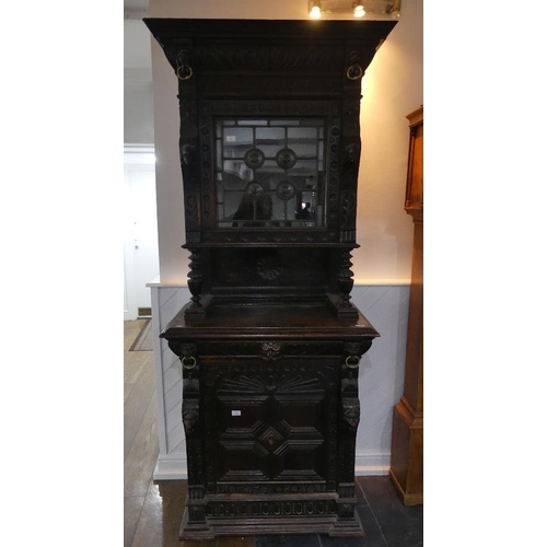 74 - A Victorian Jacobean style carved oak upright Cabinet, with moulded cornice, single leaded glass pan... 