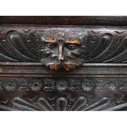 74 - A Victorian Jacobean style carved oak upright Cabinet, with moulded cornice, single leaded glass pan... 