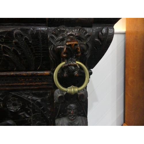 74 - A Victorian Jacobean style carved oak upright Cabinet, with moulded cornice, single leaded glass pan... 