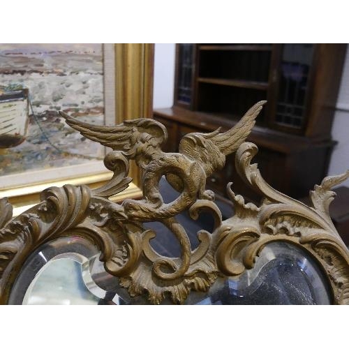 83 - A pair of early 20th century gilt metal Easel Mirrors, with bevelled edged plates, each of foliate s... 