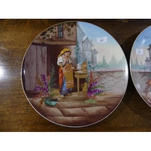 87 - A pair of early 20th century French porcelain Wall Plates, printed and painted with figures and buil... 