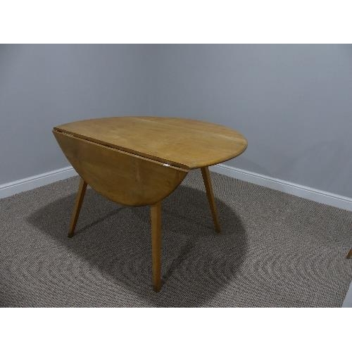 9 - A mid 20thC Ercol elm and beech drop leaf Dining Table, the elm plank top on splayed tapering beech ... 