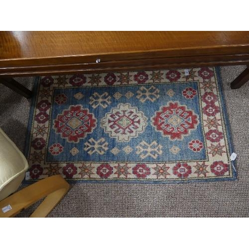 91 - Tribal Rugs; two pale blue ground small rugs, each with stylised geometric patterns in cream, light ... 