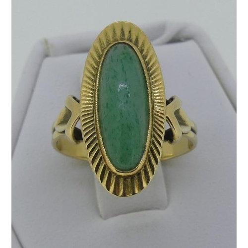 117 - A 14ct yellow gold oval Dress Ring, with a narrow cabchon jade centre within a gold sunburst border,... 