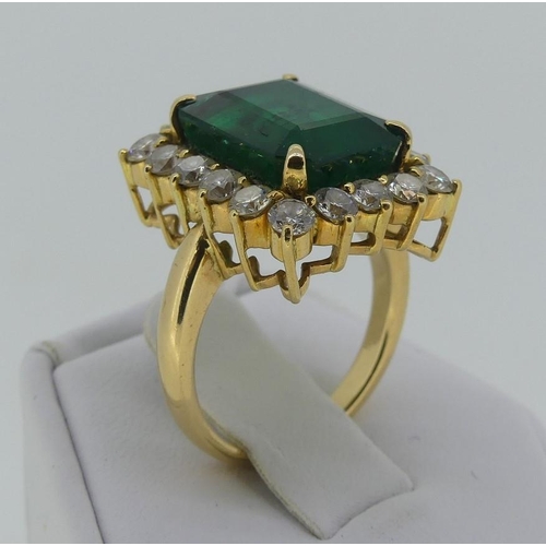 120 - A large emerald and diamond Dress Ring, the central emerald cut stone circa 7cts (39mm x 6.6mm)surro... 