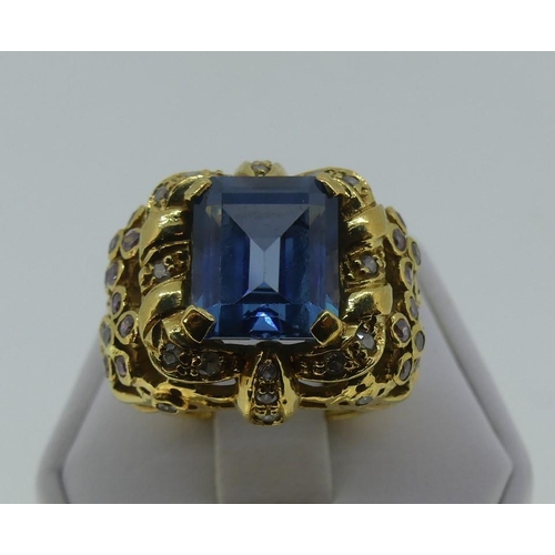 122 - A large synthetic spinel Dress Ring, the central step cut stone, 12mm x 10mm, in an elaborate mount ... 