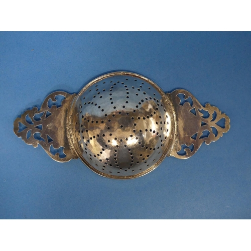 81 - An early 18thC silver Lemon Strainer, of traditional two handled form, the bowl pierced with flowerh... 