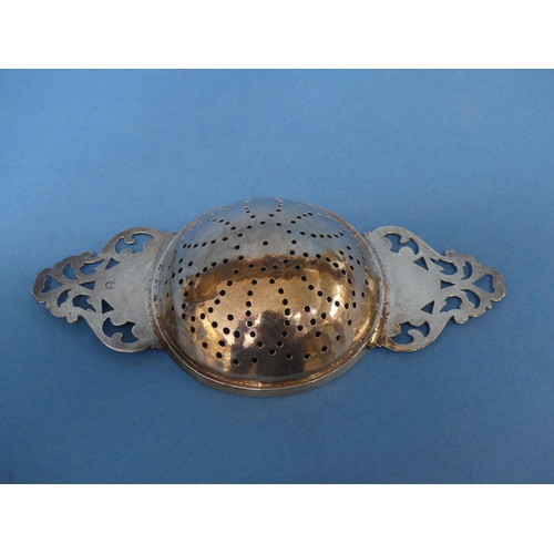 81 - An early 18thC silver Lemon Strainer, of traditional two handled form, the bowl pierced with flowerh... 