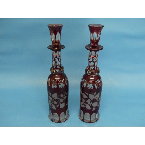 104 - A pair of early 20thC Bohemian ruby flash Decanters, bottle shape, one with chipped stopper, 13½in (... 
