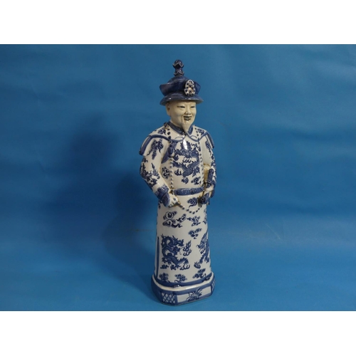111 - A 20th century Chinese blue and white porcelain figure of an Elder, behatted and holding a pipe, his... 