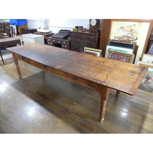 335 - A large early 20thC pine plank top Kitchen Table, with three frieze drawers, 124½in (316cm) long, 38... 