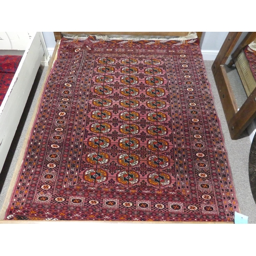 393 - Tribal rugs; an old Turkmen Bokhara dark pink ground rug, finely woven and hand knotted with repeati... 