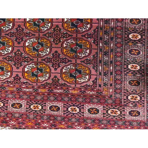 393 - Tribal rugs; an old Turkmen Bokhara dark pink ground rug, finely woven and hand knotted with repeati... 