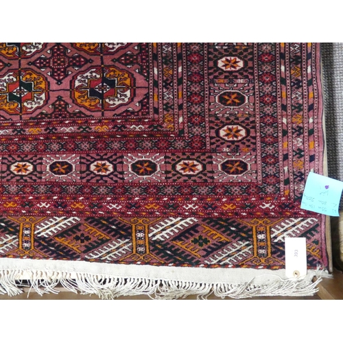 393 - Tribal rugs; an old Turkmen Bokhara dark pink ground rug, finely woven and hand knotted with repeati... 