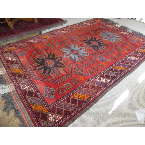 396 - Tribal rugs; an old Caucasian Kazak red ground rug, coarsely woven and hand knotted with four centra... 