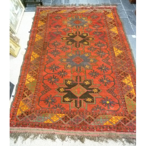 397 - Tribal rugs; an old Caucasian Kazak red ground rug, coarsely woven and hand knotted with date cartou... 