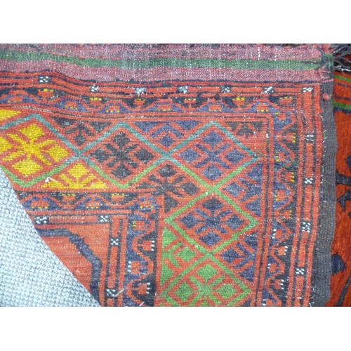 397 - Tribal rugs; an old Caucasian Kazak red ground rug, coarsely woven and hand knotted with date cartou... 