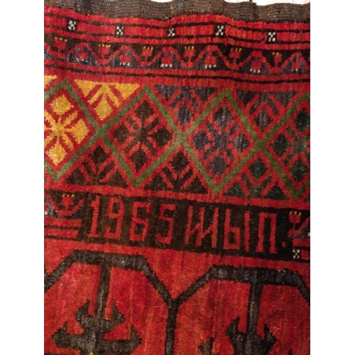 397 - Tribal rugs; an old Caucasian Kazak red ground rug, coarsely woven and hand knotted with date cartou... 