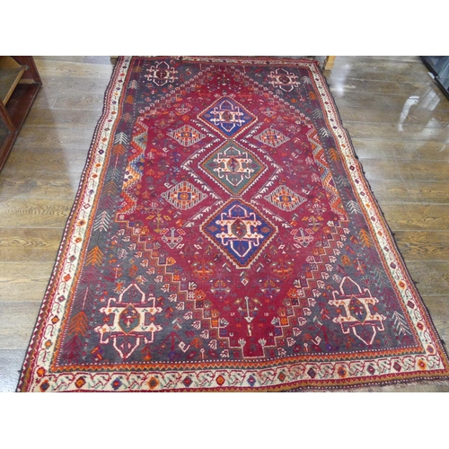 450 - Tribal rugs; a Persian Qashqai red and blue ground rug, the whole woven with stylised tree of life a... 