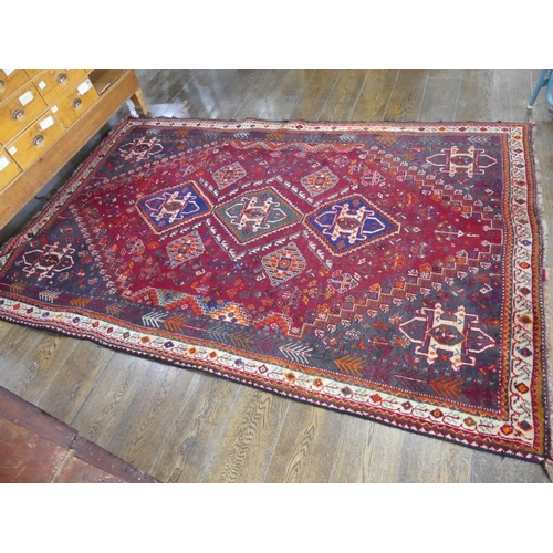 450 - Tribal rugs; a Persian Qashqai red and blue ground rug, the whole woven with stylised tree of life a... 