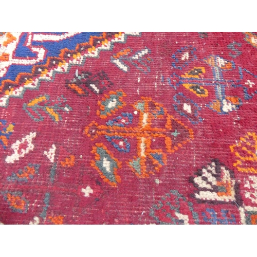 450 - Tribal rugs; a Persian Qashqai red and blue ground rug, the whole woven with stylised tree of life a... 